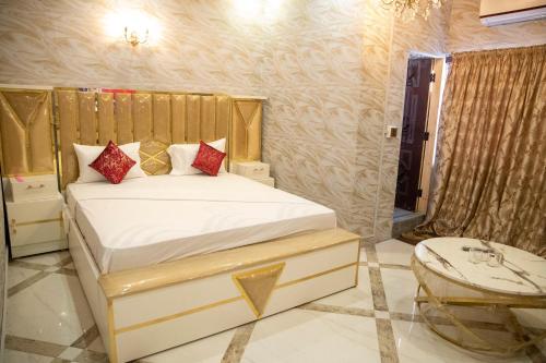 a bedroom with a bed with red pillows on it at The Red Tree II Executive Guest House in Karachi