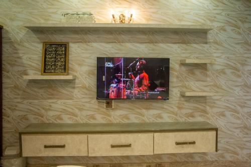 a flat screen tv hanging on a wall at The Red Tree II Executive Guest House in Karachi