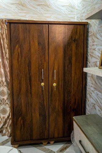 a wooden cabinet in the corner of a room at The Red Tree II Executive Guest House in Karachi