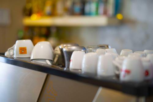 a bunch of white cups sitting on a shelf at Hotel Sant'Elena in Rimini