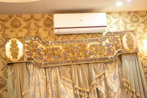 a wall mounted air conditioner in a room with curtains at The Red Tree II Executive Guest House in Karachi