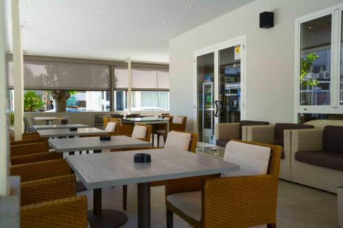 a restaurant with tables and chairs and windows at Hotel Sant'Elena in Rimini