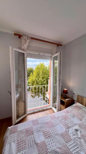 エンプリアブラバにあるApartamento cerca del marのベッドと大きな窓のある寝室