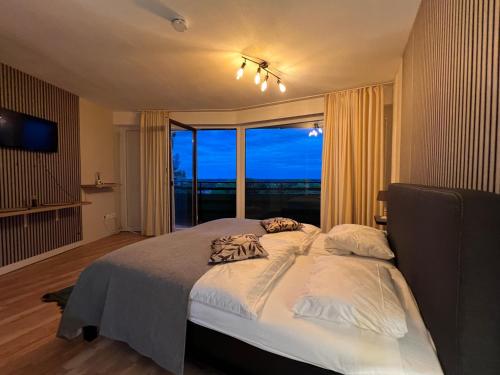 a bedroom with a large bed and a large window at Apart-Hotelzimmer mit Bergblick in Bad Essen in Bad Essen