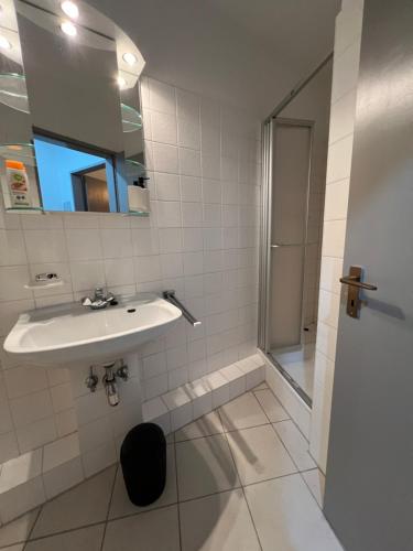 a bathroom with a sink and a shower at Apart-Hotelzimmer mit Bergblick in Bad Essen in Bad Essen
