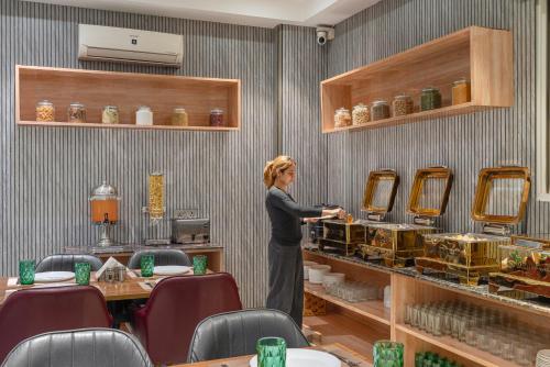 a woman standing in a room with a counter at Lime Tree Hotel & Stays Greater Noida Nearby India Expo Centre & Mart in Greater Noida