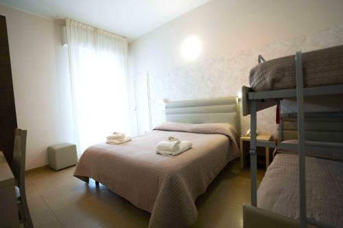 a bedroom with two bunk beds and a window at Hotel Sant'Elena in Rimini