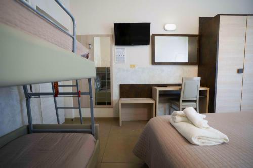 a bedroom with a bunk bed and a desk with a chair at Hotel Sant'Elena in Rimini