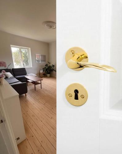 a room with a door with a spoon and a kitchen at Cosy City Apartment in Odense