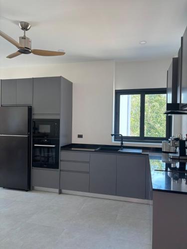 a kitchen with black appliances and a ceiling fan at Villa Thai Sabai 2, Lamai in Lamai