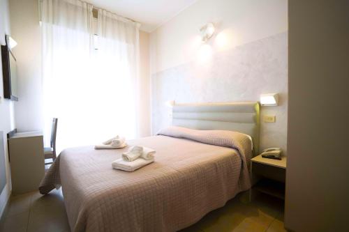 a bedroom with a bed with two towels on it at Hotel Sant'Elena in Rimini