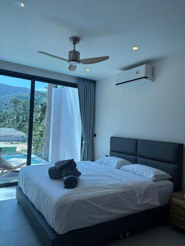 a bedroom with a bed with a ceiling fan at Villa Thai Sabai 2, Lamai in Lamai