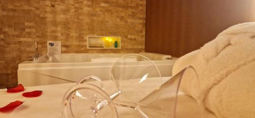 a bathroom with a tub and a table with red roses at La Cadurcienne "Love room" jacuzzi & pièce secrète Cahors centre historique in Cahors