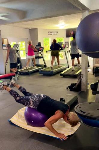 a man laying on a ball in a gym at Best Western Grand Baymen Gardens in San Pedro