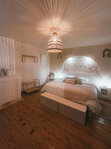 a bedroom with a large bed with a large ceiling at Le Logis de la Gabirotte in Nieulle-sur-Seudre