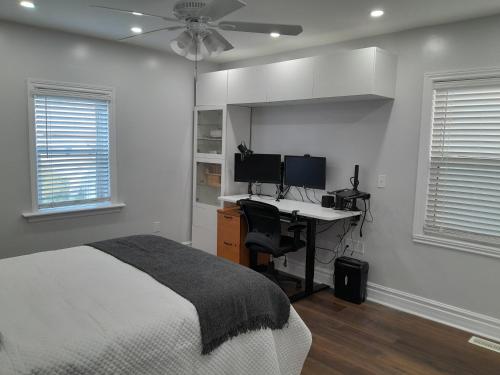 a bedroom with a bed and a desk with a computer at The Cozy Bungalow in North York Nest in Toronto