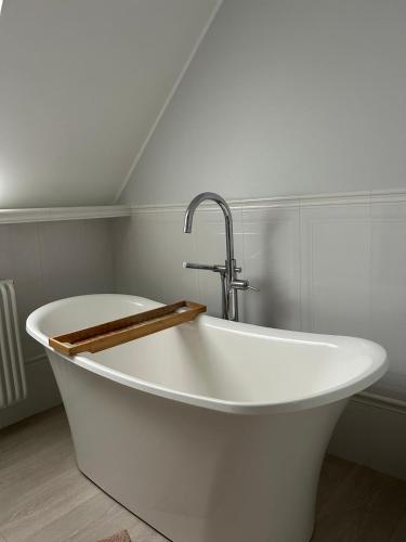 a white bath tub with a faucet in a bathroom at Apartamenty Smile 2 in Grudziądz