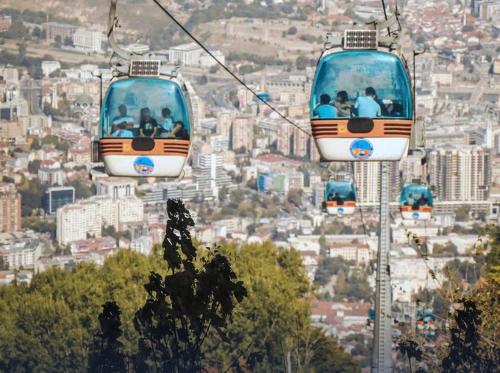 two cable cars are flying over a city at SKOPJE Apartment in Skopje