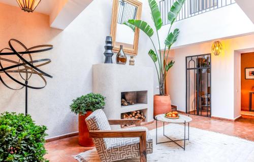 sala de estar con chimenea y plantas en Riad Librah Kasbah, médina Place JAMEAA LEFNA, en Marrakech