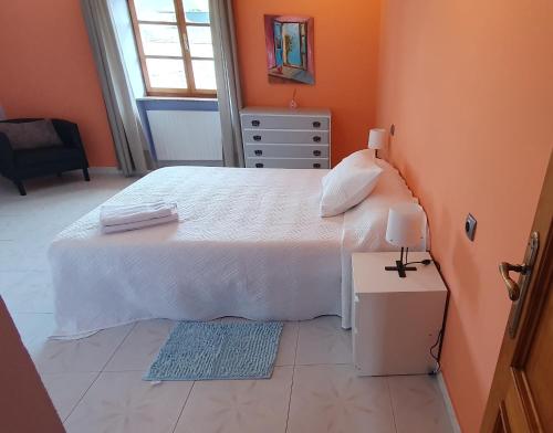 a bedroom with a large white bed with orange walls at Casa Rural Nito in Villayón