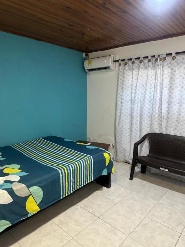 a bedroom with a bed and a chair in a room at Jhonny Cay Collection Apartahotel in San Andrés