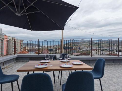 a table with chairs and an umbrella on a balcony at Endrit Accommodation in Vorë