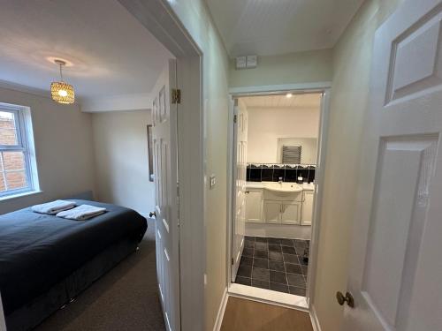 a bedroom with a bed and a small bathroom at Ely Stays Flat 2 City Center in Ely