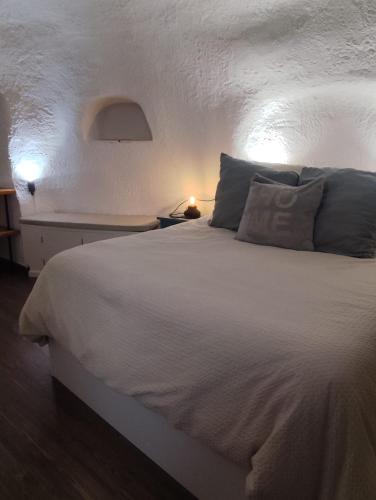 a bedroom with a large white bed with pillows at Cueva la estrella in Chinchilla de Monte Aragón