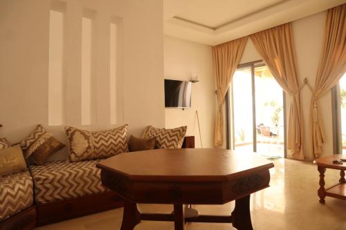 a living room with a couch and a table at Surf and Stay Villa Anza Taghazout Tamraght in Agadir