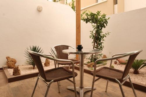 a patio with a table and chairs and plants at Surf and Stay Villa Anza Taghazout Tamraght in Agadir