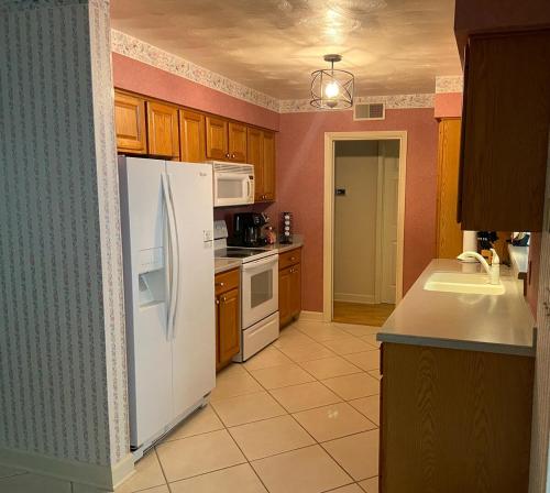 a kitchen with a white refrigerator and a sink at Beautiful Pool, Close To Beaches in Largo