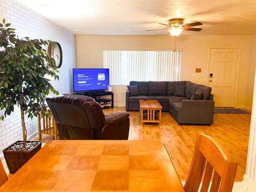 a living room with a couch and a tv at Beautiful Pool, Close To Beaches in Largo