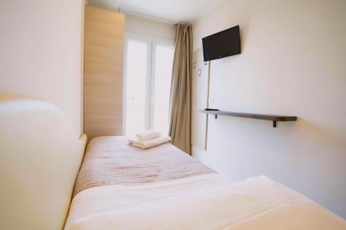 a bedroom with a bed with a tv on the wall at Hotel Sant'Elena in Rimini