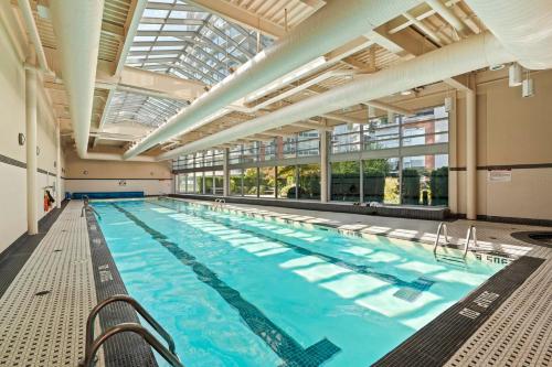 a large indoor swimming pool with a large ceiling at Cozy Urban Living! 2 mins from BC place, private parking ! in Vancouver