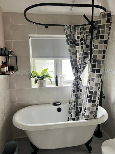 a bath tub in a bathroom with a window at Stay Solihull Large spacious home in Solihull close to NEC HS2 Bham Airport in Solihull