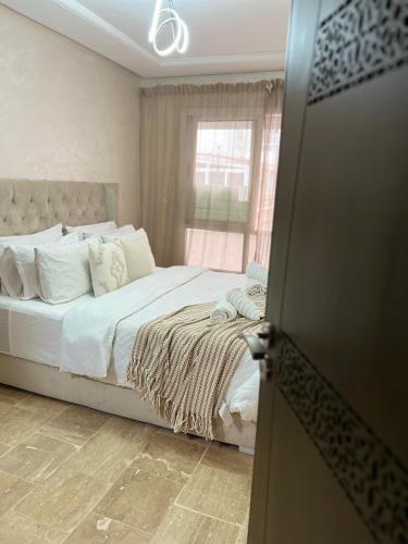 a bedroom with a bed with white sheets and a window at Casa omar in Tangier