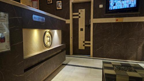 a lobby with a clock on the wall and a television at Hotel Prince B in Guwahati