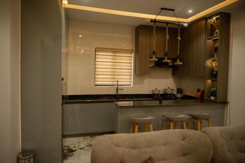 a kitchen with a counter and stools in a room at Two Bedroom Luxe Apt Awka in Awka