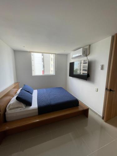 a bedroom with a bed with blue pillows on it at Apartamento Sur de Cali in Cali