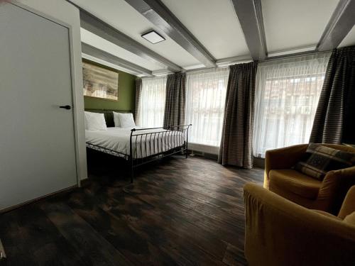 a bedroom with a bed and a couch and windows at Central Guest Rooms in Amsterdam