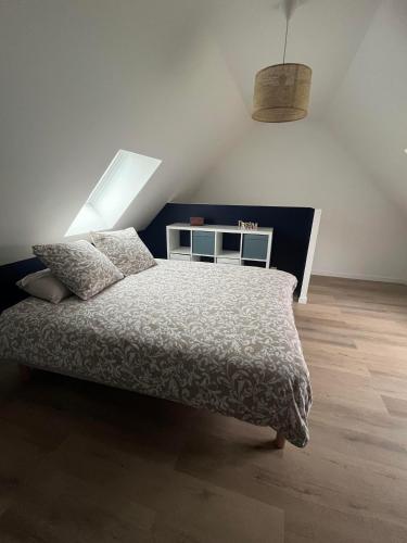 a bedroom with a bed with a white comforter at Chez Colette- Maison avec jardin in Acquigny