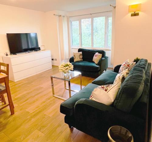 a living room with a couch and a tv at 2-Bed Apartment Near ExCeL - Free Parking & WiFi - Ideal for Families, Business & Leisure in London