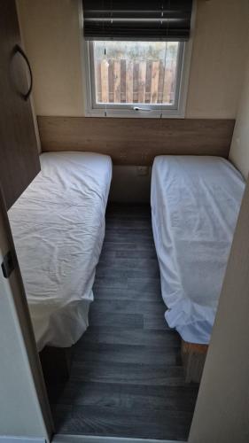 two beds in a small room with a window at R12 Golden sands in Kinmel Bay