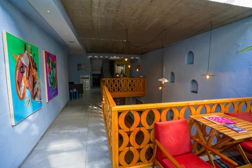 a dining room with a wooden table and red chairs at Ura Hostel in Prizren