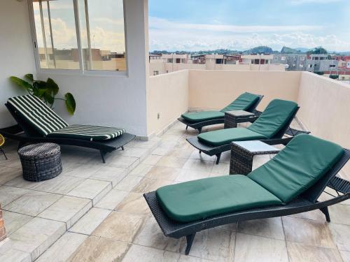 a row of chairs and tables on a balcony at Casa Sauces Sur, alberca, billar, roof garden privado in Emiliano Zapata