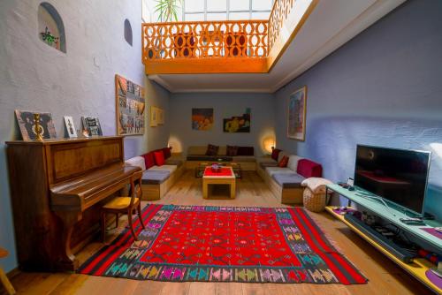 a living room with a piano and a couch at Ura Hostel in Prizren