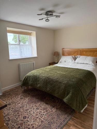 a bedroom with a large bed and a window at Beautiful Barn Conversion Wyboston in Bedford