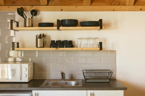 a kitchen with a sink and shelves with dishes at Camping IZARPE in Aróstegui