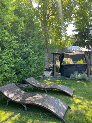two benches sitting in a yard with a gazebo at Secret Garden Vendégház in Pécs