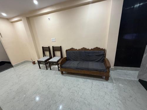 a room with a bed and two chairs in it at Riddhi kitchen in Silao